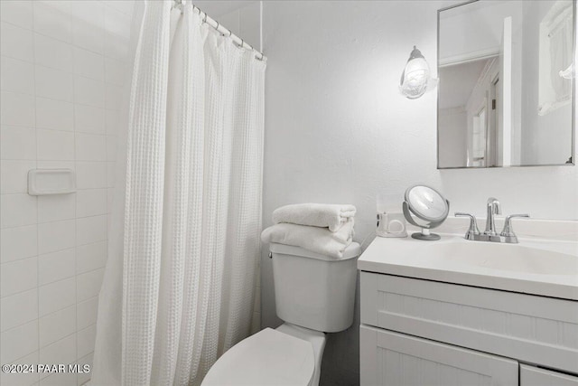 bathroom featuring a shower with shower curtain, vanity, and toilet