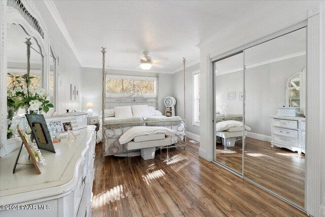 bedroom with a closet, dark hardwood / wood-style floors, ceiling fan, and crown molding