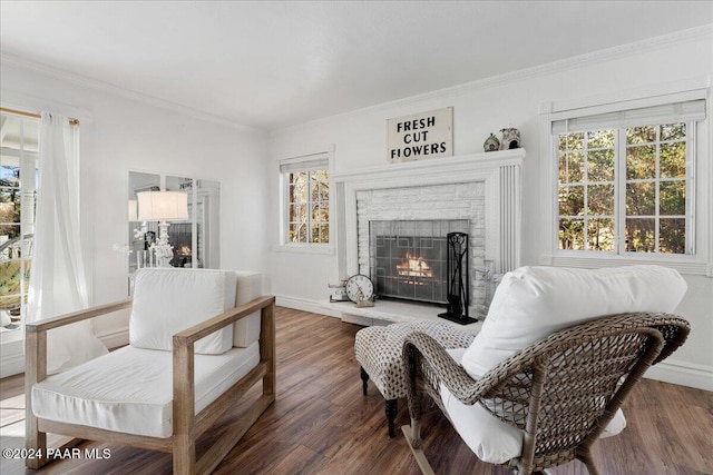 sitting room with dark hardwood / wood-style flooring, crown molding, and a wealth of natural light