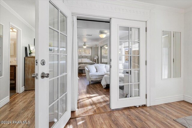 doorway to outside with french doors, wood-type flooring, and ornamental molding