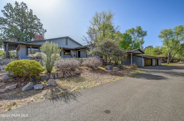 2008 N Williamson Valley Rd, Prescott, AZ 86305 - mid-century modern home with a chimney, an attached garage, and driveway