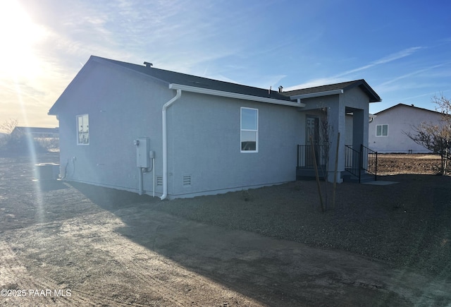 rear view of house with stucco siding