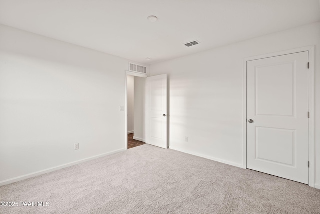 unfurnished bedroom with carpet, visible vents, and baseboards