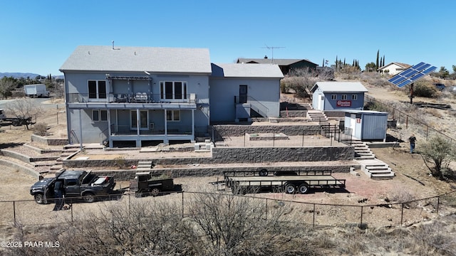 back of property featuring stairway and fence