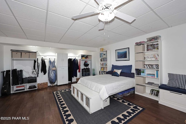 bedroom with dark wood finished floors, a paneled ceiling, and ceiling fan