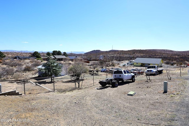 view of yard featuring fence and a mountain view