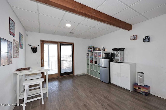 interior space featuring beamed ceiling, a paneled ceiling, dark wood-type flooring, and visible vents