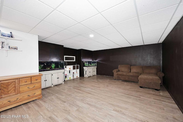 living area featuring light wood finished floors and a paneled ceiling