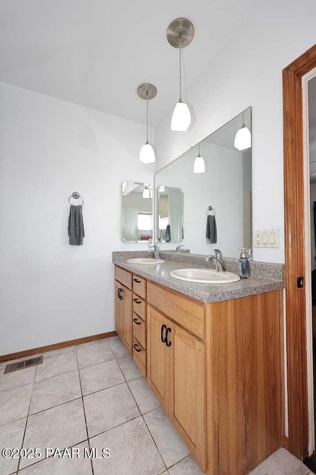 full bathroom featuring double vanity, visible vents, tile patterned floors, and a sink