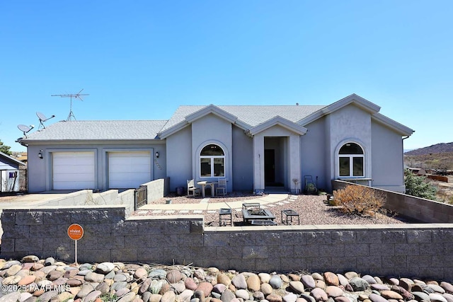 ranch-style house featuring a garage, fence, concrete driveway, and stucco siding