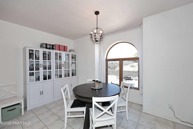 dining room with an inviting chandelier, light tile patterned flooring, and baseboards