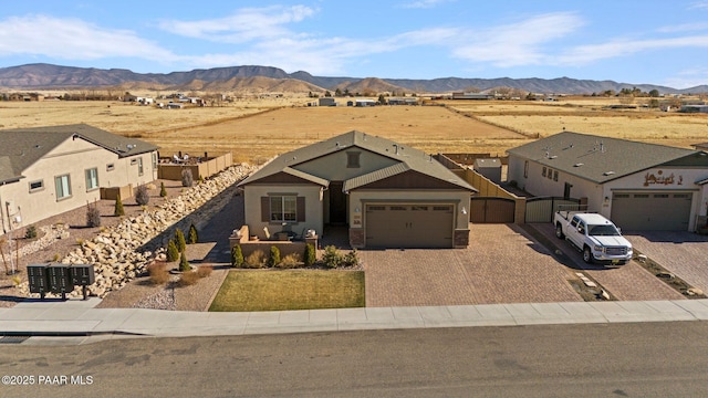 view of front of house featuring a garage, decorative driveway, and a mountain view