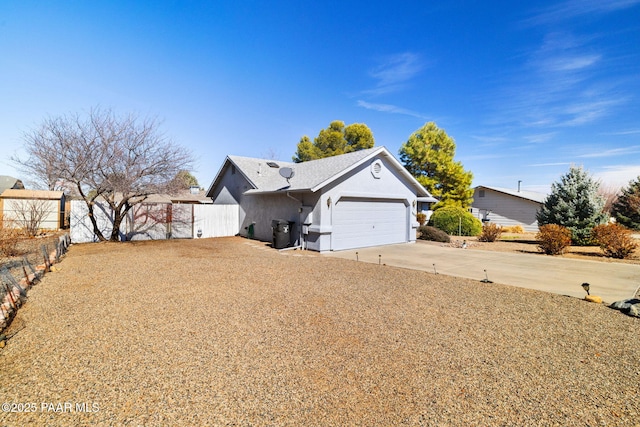 exterior space featuring a garage, driveway, and fence