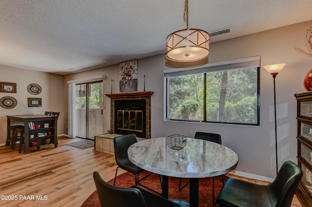 1434 Haisley Ct, Prescott, AZ 86303 - dining room with a textured ceiling, light wood-type flooring, a tile fireplace, and baseboards