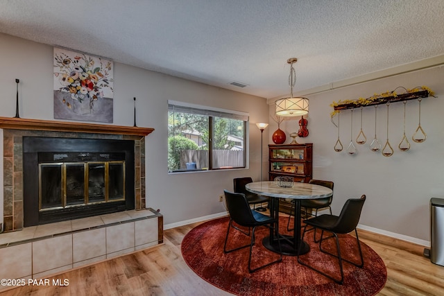 1434 Haisley Ct, Prescott, AZ 86303 - dining area with a textured ceiling, wood finished floors, a tiled fireplace, and baseboards