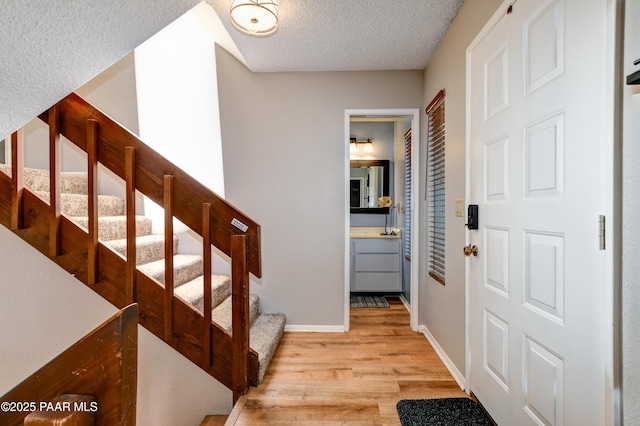 1434 Haisley Ct, Prescott, AZ 86303 - foyer entrance featuring light wood-type flooring, stairs, a textured ceiling, and baseboards