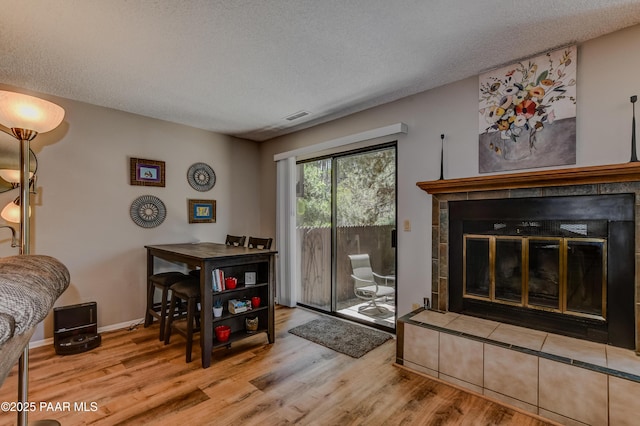 1434 Haisley Ct, Prescott, AZ 86303 - dining room with a textured ceiling, a tile fireplace, wood finished floors, and baseboards