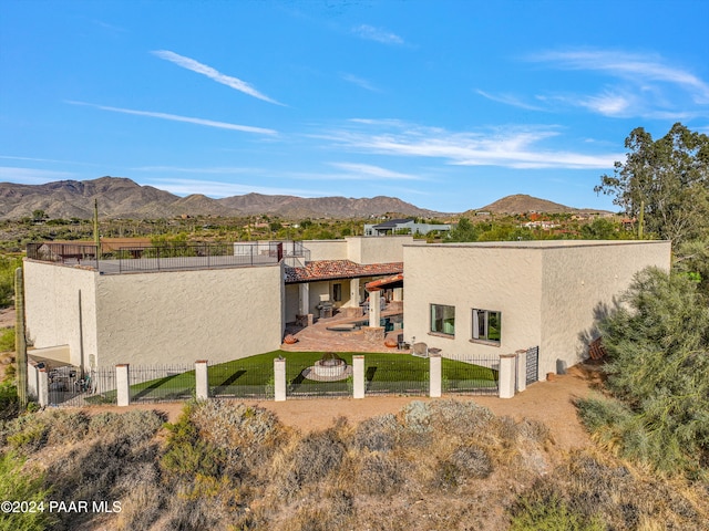 back of house featuring a mountain view and a yard