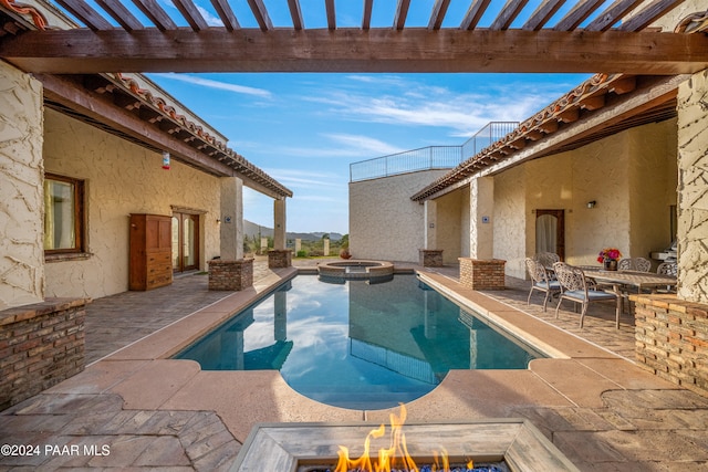 view of pool featuring a fire pit, a mountain view, a patio area, and an in ground hot tub