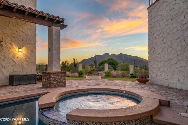 exterior space featuring a mountain view and an in ground hot tub