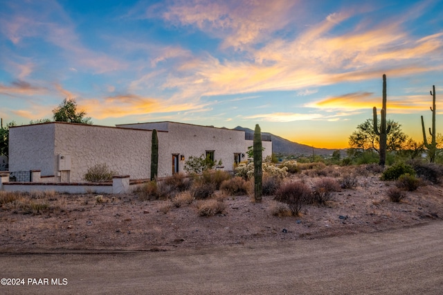 property exterior at dusk with a mountain view