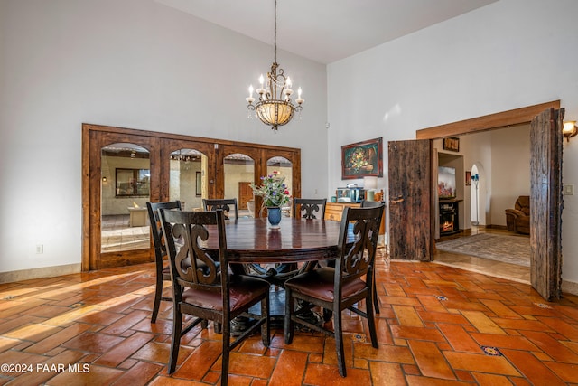 dining room with a high ceiling and an inviting chandelier