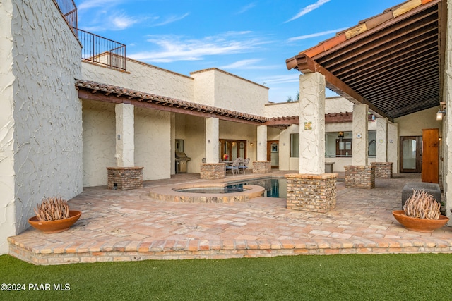 view of patio / terrace featuring an in ground hot tub and a balcony