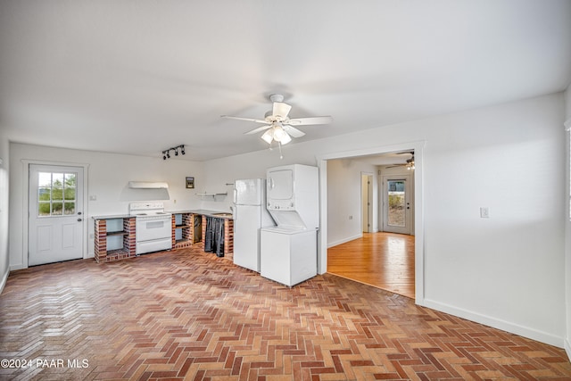 kitchen featuring white appliances, ventilation hood, stacked washer and clothes dryer, light hardwood / wood-style floors, and white cabinetry