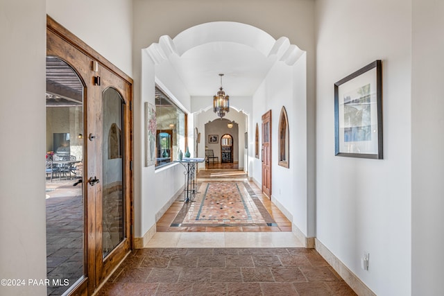 hall featuring a notable chandelier and french doors