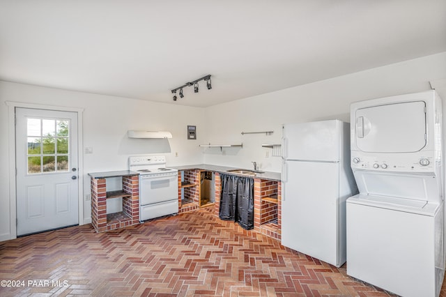 kitchen with white appliances, track lighting, sink, stacked washer and dryer, and range hood