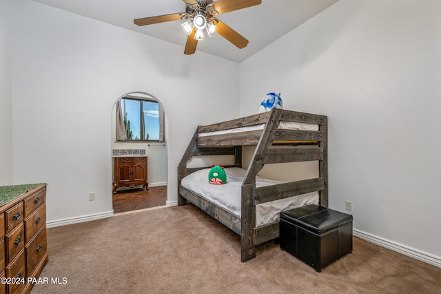 bedroom featuring ceiling fan, dark carpet, and vaulted ceiling