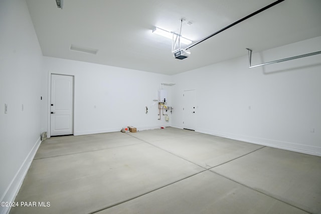 garage featuring baseboards, tankless water heater, and a garage door opener