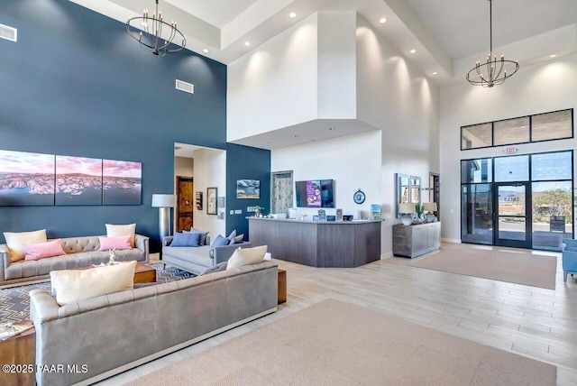 living room with light wood finished floors, recessed lighting, visible vents, and a notable chandelier