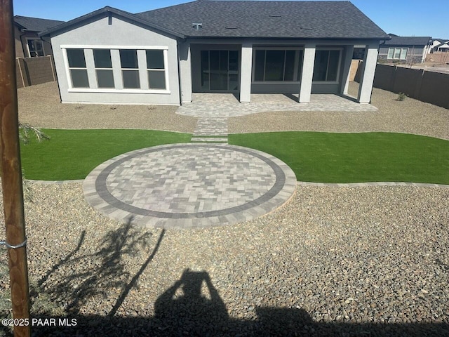 back of house with a patio area, a fenced backyard, roof with shingles, and stucco siding