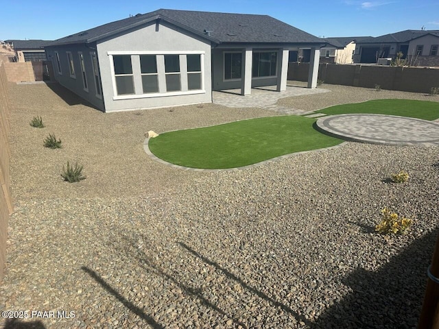 rear view of house featuring a patio area, a fenced backyard, and stucco siding