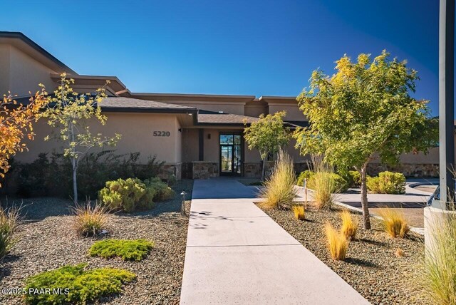 view of front of home with stone siding and stucco siding