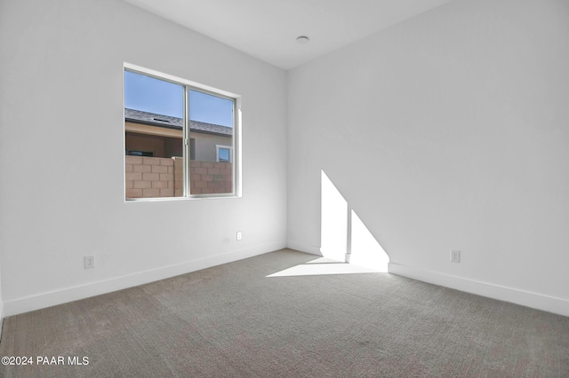 unfurnished room with baseboards and carpet flooring