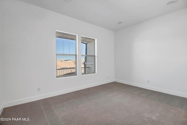 unfurnished room with baseboards and carpet flooring