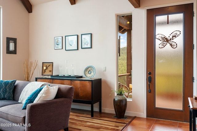 interior space with baseboards and beam ceiling
