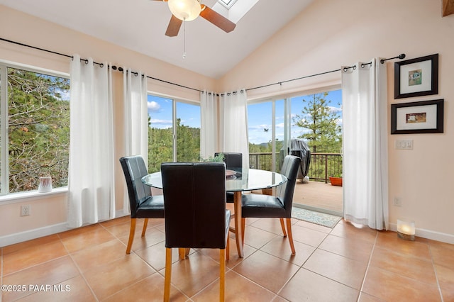 dining space with baseboards, a ceiling fan, light tile patterned floors, and lofted ceiling