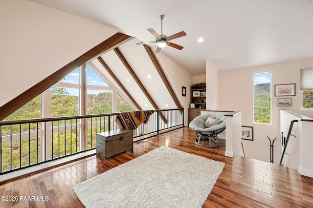 interior space with a healthy amount of sunlight, hardwood / wood-style floors, ceiling fan, and beam ceiling