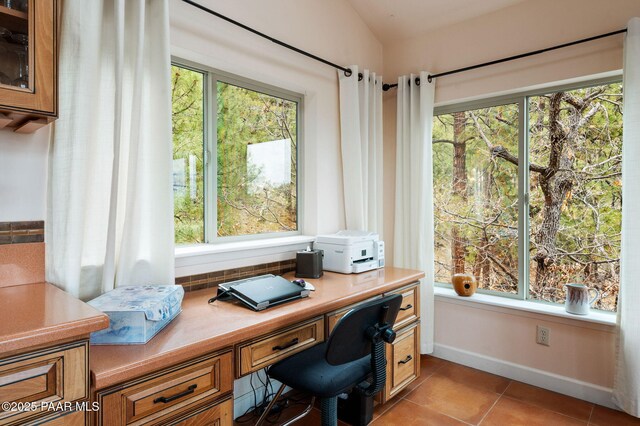 office with baseboards, light tile patterned flooring, and built in desk