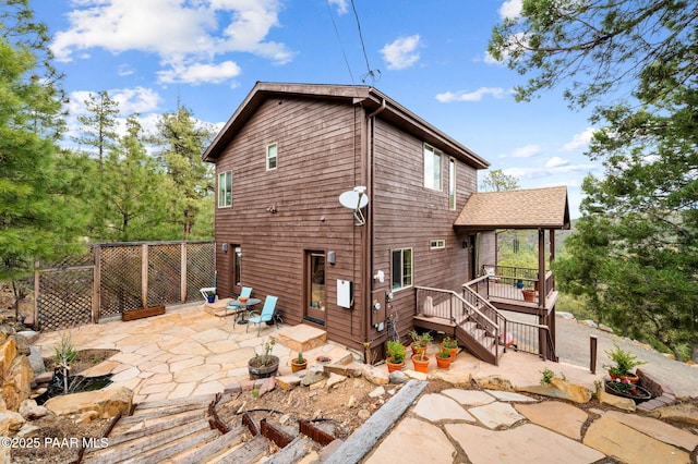 rear view of house with a patio, fence, and a deck