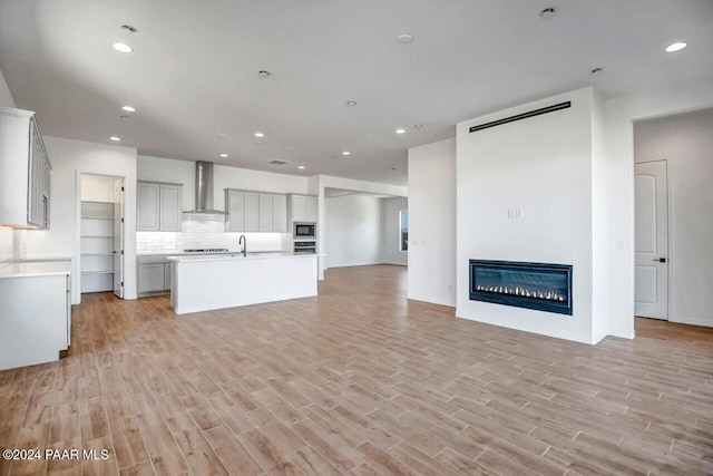 unfurnished living room featuring light wood-type flooring and sink