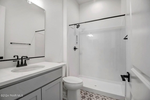 bathroom featuring vanity, toilet, and walk in shower