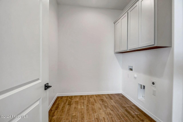 washroom with hookup for an electric dryer, hookup for a washing machine, light hardwood / wood-style flooring, and cabinets