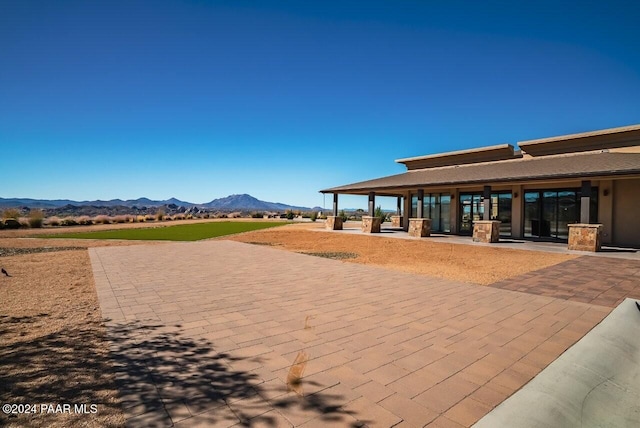 view of home's community with a mountain view and a patio