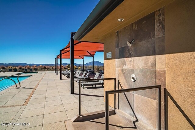 view of swimming pool with a mountain view and a patio area