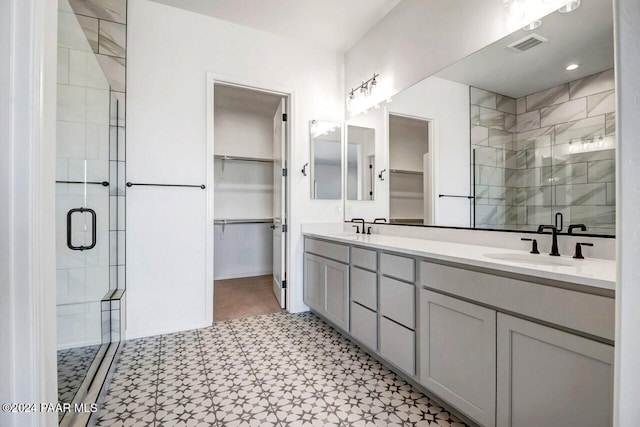 bathroom with vanity and a shower with door