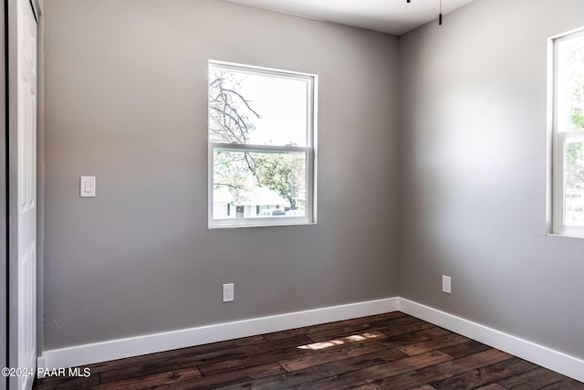 spare room featuring dark hardwood / wood-style floors and a wealth of natural light